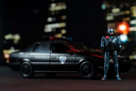 Autíčko RoboCop Ford Taurus 1986 Jada kovové s otvárateľnými časťami a figúrkou Robocop dĺžka 20 cm 1:24